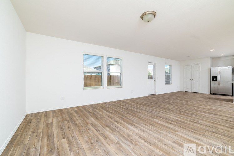 A spacious room with wooden flooring and white walls.