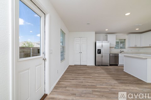 A kitchen with white cabinets and a refrigerator.