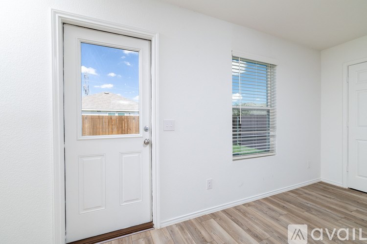 A room with a white door and a window with blinds.