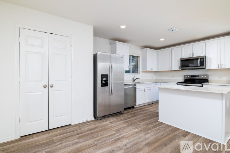 A kitchen with white cabinets and a stainless steel refrigerator.
