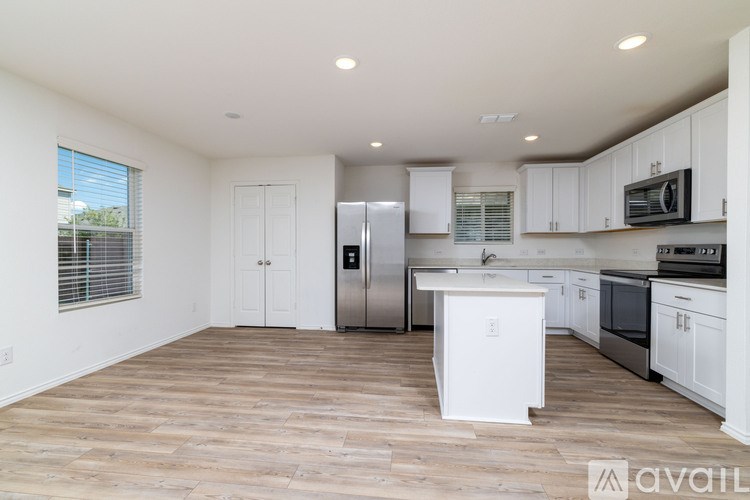 A kitchen with white cabinets and a wooden floor.