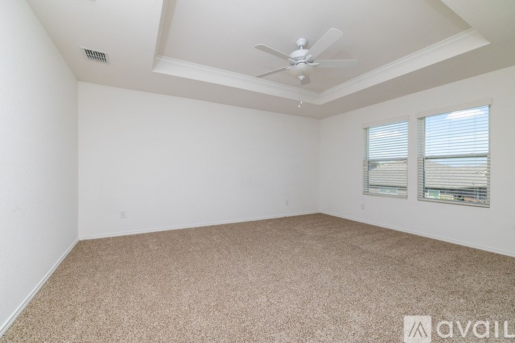 A room with a carpeted floor and a ceiling fan.