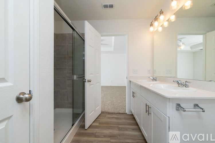 A bathroom with a white door, a white sink, and a mirror.