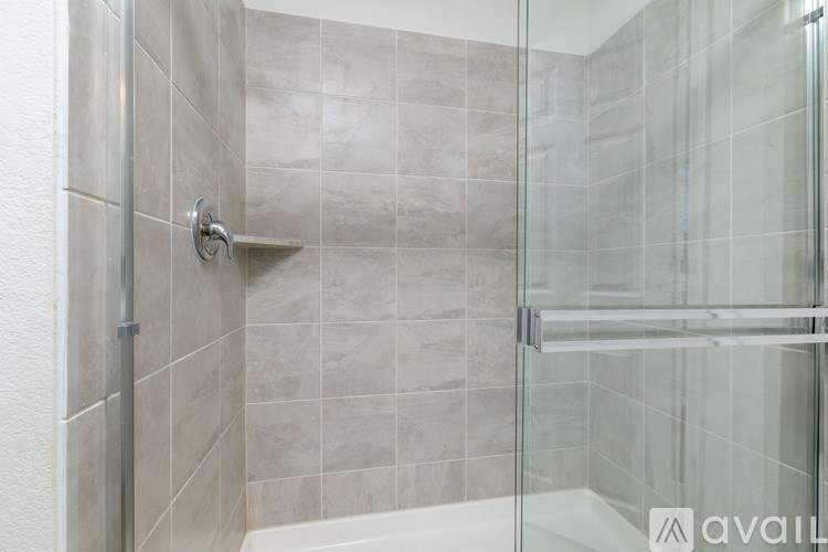A shower area with a glass door and a shower head.
