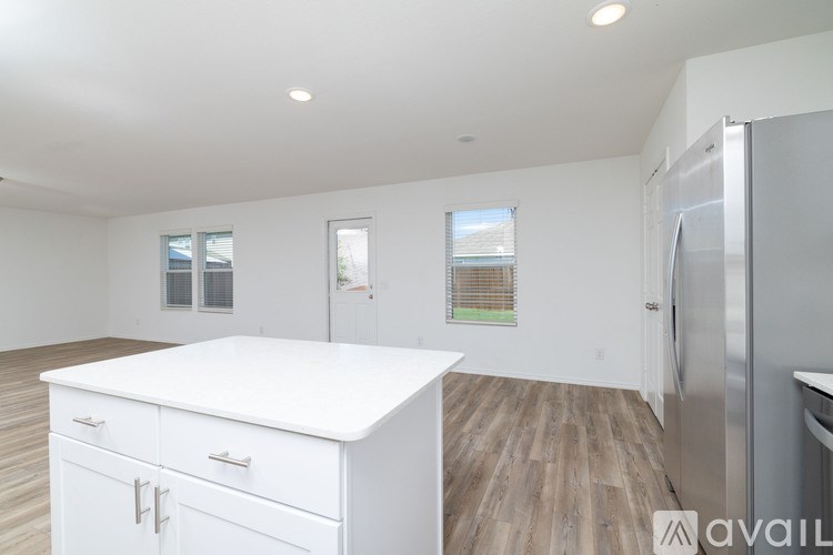 A kitchen with white cabinets and a wooden floor.