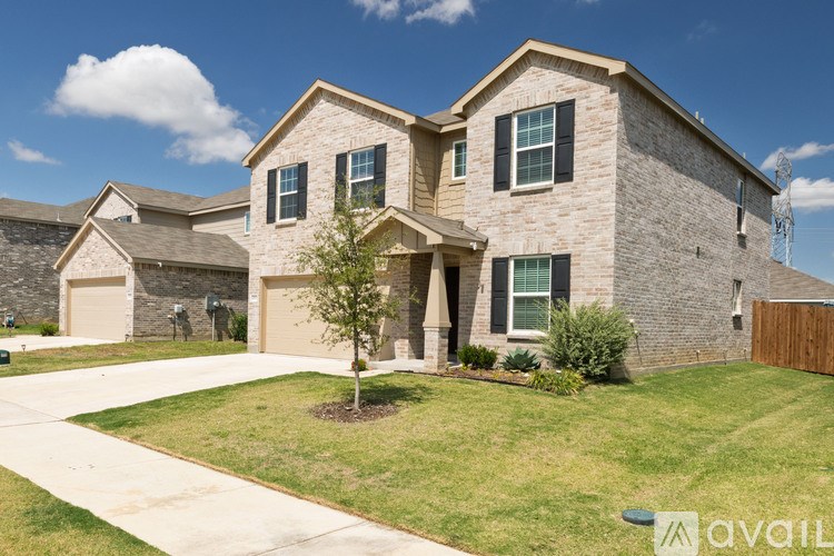 A house with a stone exterior and a tree in front.