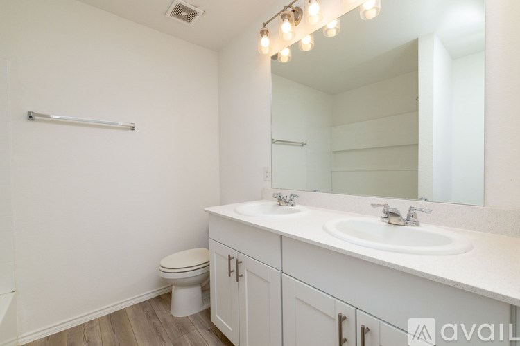 A bathroom with a toilet, sink, and mirror.