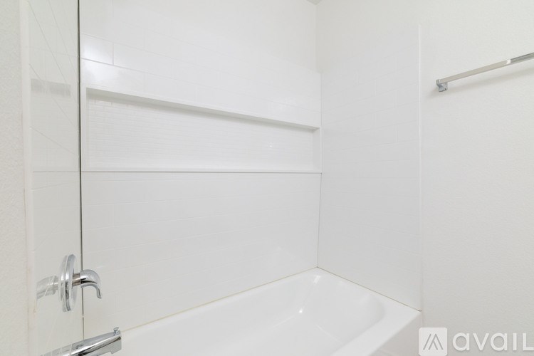 A white bathroom with a glass shower door and a white tub.