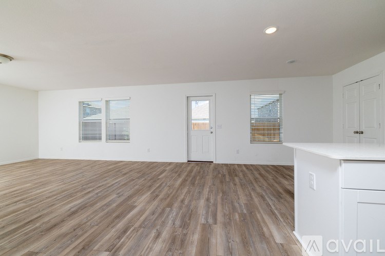 A room with wooden flooring and white walls.