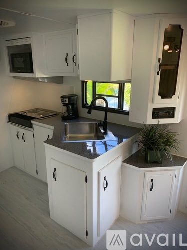 A kitchen with white cabinets and a black stove top.