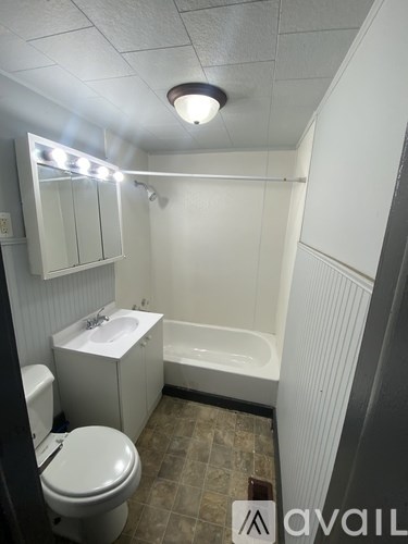 A small bathroom with a toilet, sink, and bathtub.