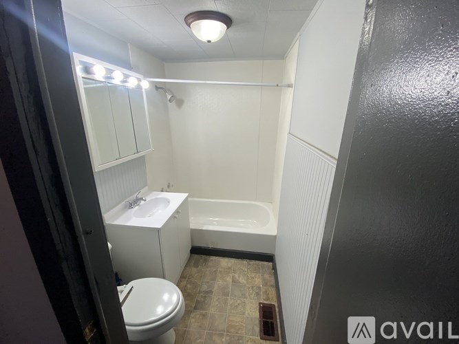 A bathroom with a toilet, sink, and bathtub.