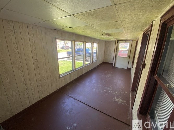 A room with wooden walls and a brown floor.