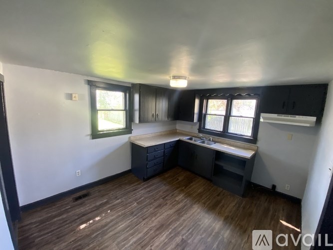 A room with wooden floors and a window with blinds.