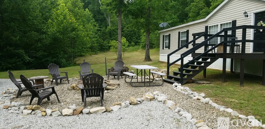 A patio with a table and chairs is surrounded by a gravel area.
