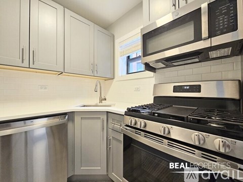 A modern kitchen with a stove top oven and microwave above it.