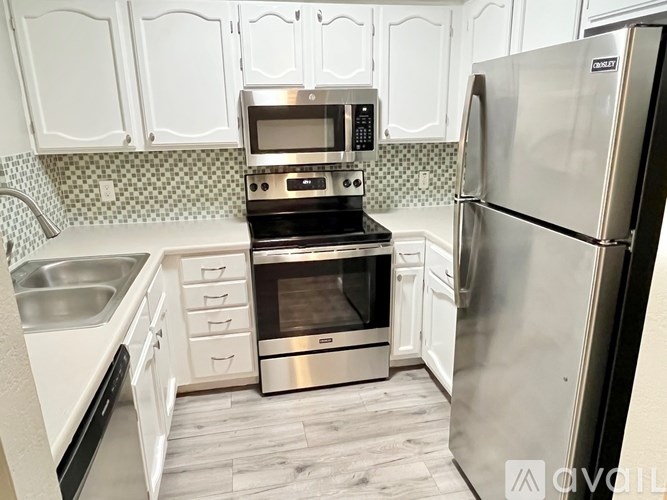 A kitchen with a stainless steel refrigerator, oven, and microwave.