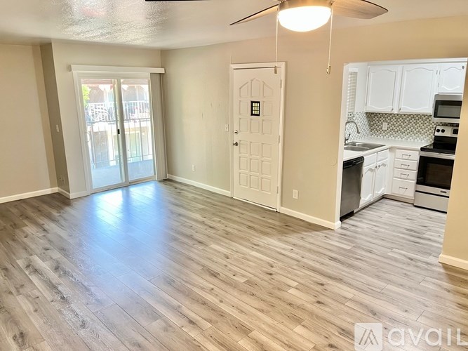 A room with a wooden floor and a ceiling fan.