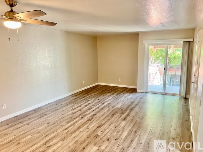 A room with wooden flooring and a ceiling fan.