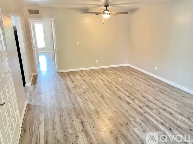 A room with wooden flooring and a ceiling fan.