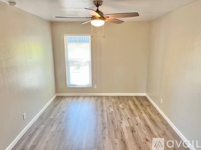 A room with a ceiling fan and a window.