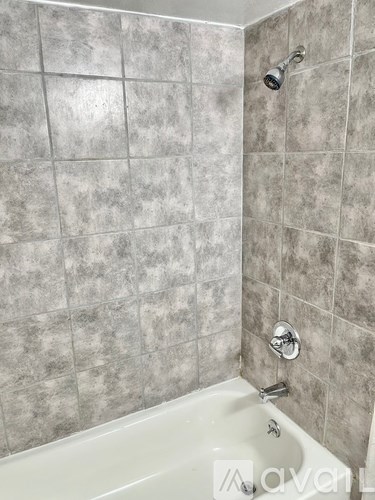 A bathroom with a tiled shower and tub.