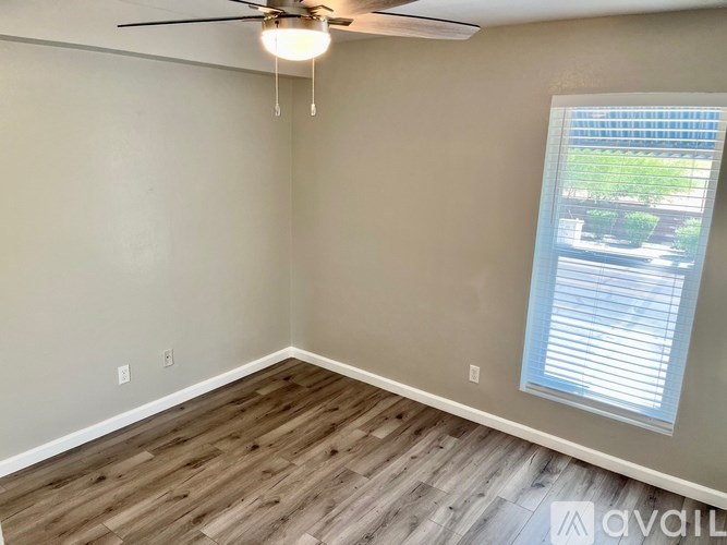 A room with a ceiling fan and a window with blinds.