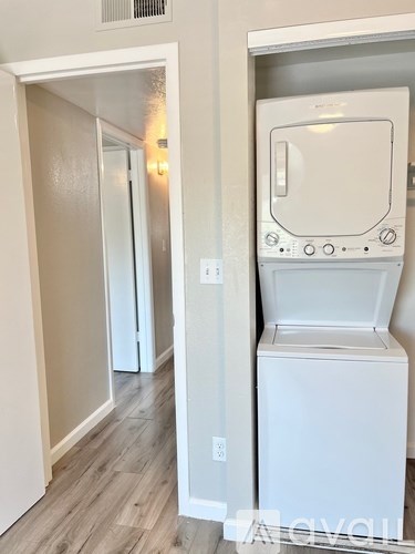 A white dryer is in a small room with a door open.