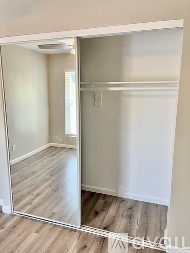 A room with a white door and a wooden floor.