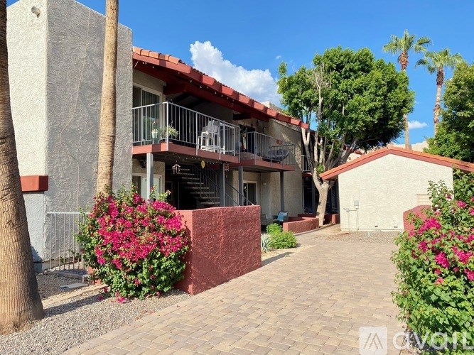 A building with a red roof and a balcony with a railing.