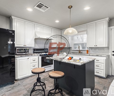 A modern kitchen with white cabinets and a central island.