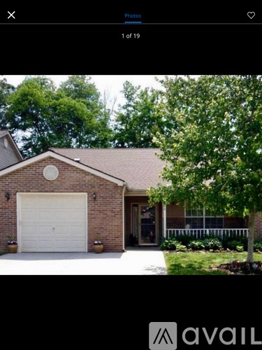 A house with a white garage door and a brick facade.