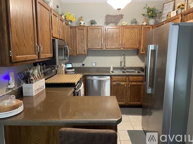 A kitchen with wooden cabinets and a stainless steel refrigerator.