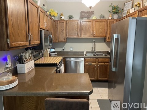 A kitchen with wooden cabinets and a stainless steel refrigerator.