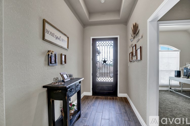 A hallway with a black door and a mirror on the wall.