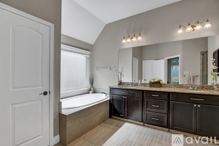A bathroom with a tub, sink, and mirror.