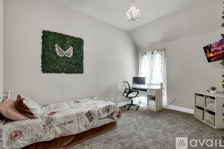 A bedroom with a bed, desk, and chair.