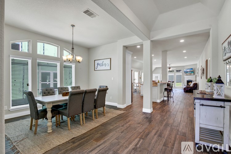 A dining room with a white table and chairs.