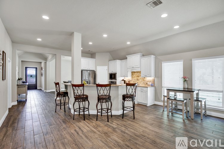 A spacious kitchen with white cabinets and a center island.