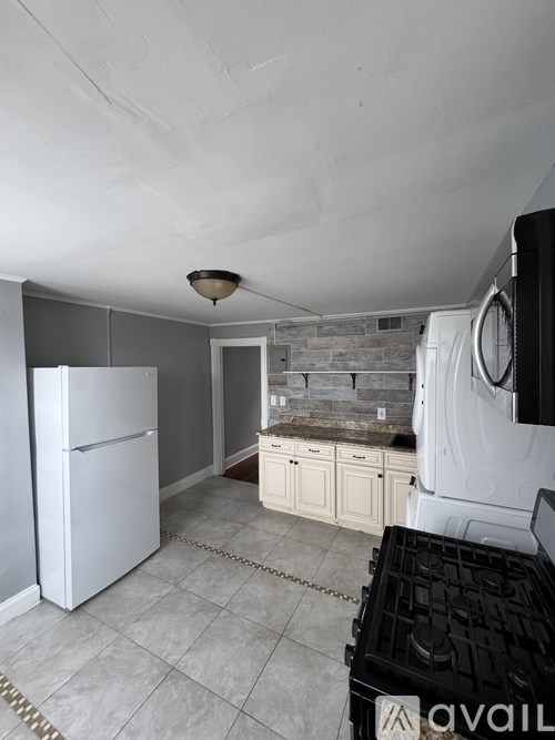 A kitchen with a white refrigerator and a black dishwasher.