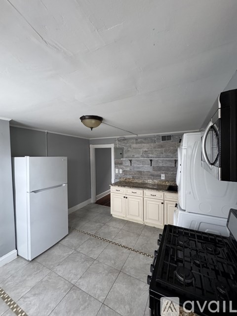A kitchen with a white refrigerator and a black dishwasher.