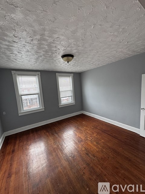 A room with wooden floors and a textured ceiling.