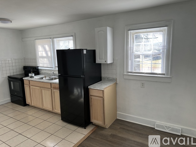A kitchen with black appliances and wooden cabinets.