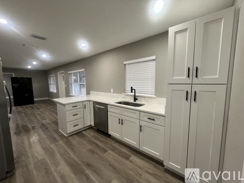 A kitchen with white cabinets and a sink.