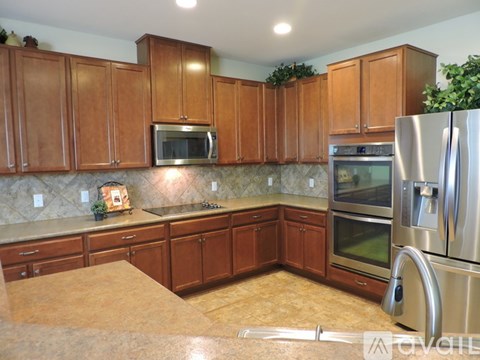 A kitchen with brown cabinets and stainless steel appliances.