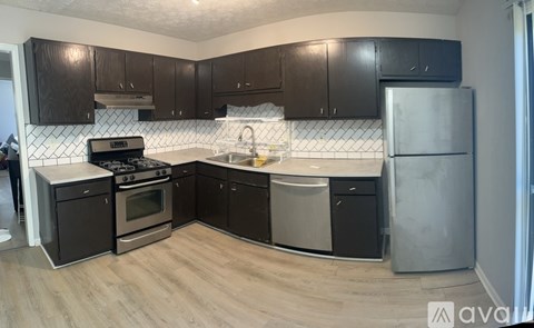 A kitchen with black cabinets and a white backsplash.