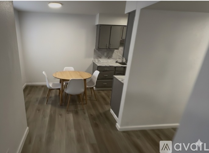 A kitchen area with a table and chairs.
