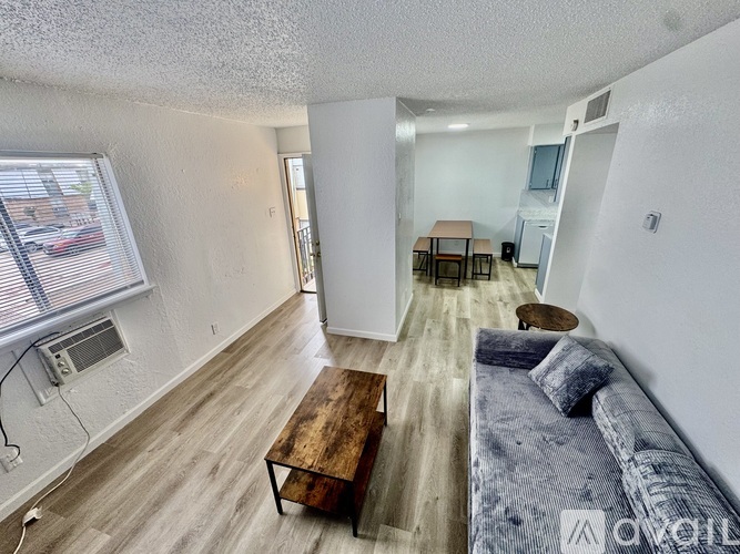 A living room with a grey couch and a wooden coffee table.