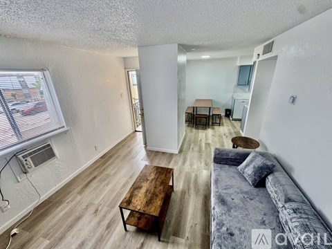 A living room with a grey couch and a wooden coffee table.
