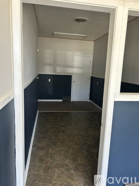 A hallway with a white door and a tiled floor.